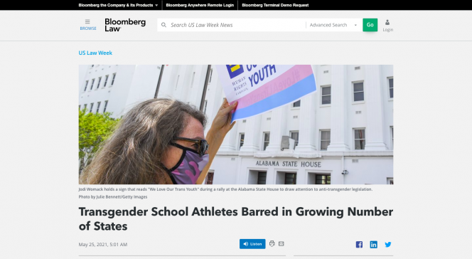 A woman wearing a mask holding a trans flag. The headline is underneath the image