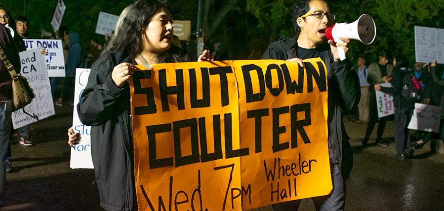Two students holding a banner that says "Shut down Coulter. Wed 7 PM Wheeler Hall."