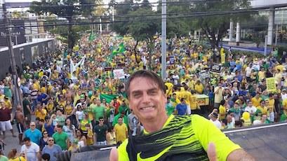 A casually dressed Bolsonaro giving the camera two thumbs up
