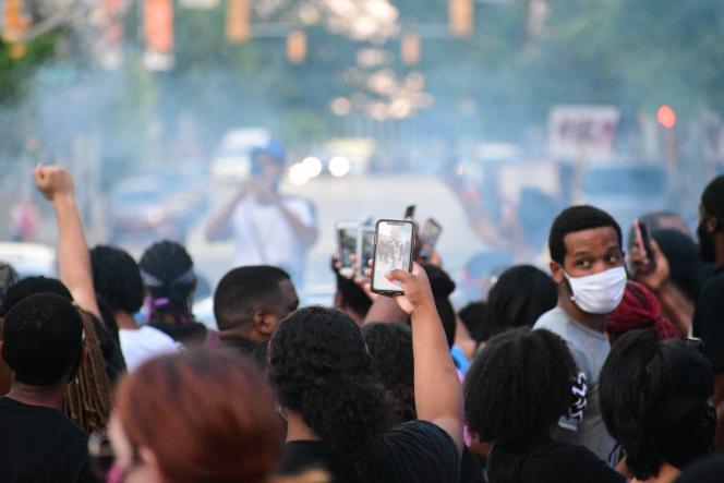 A group photo of protesters wearing masks and holding up phones