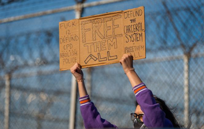 a person holding a sign that reads "Free them all"