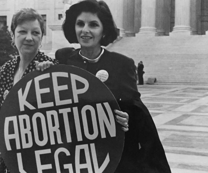 Two women on the steps of the Supreme Court holding a sign that says "Keep Abortion Legal."