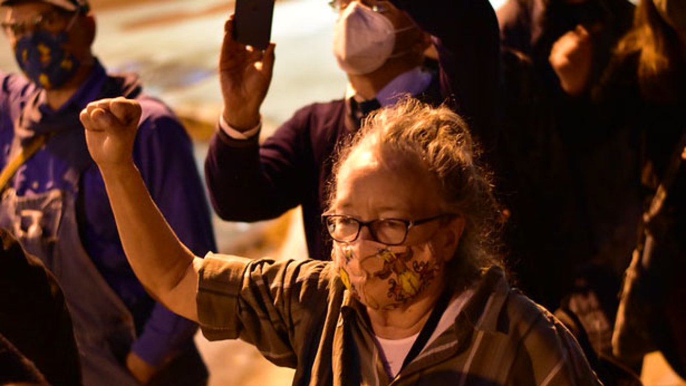 An older lady in a shirt with her fist in the air.