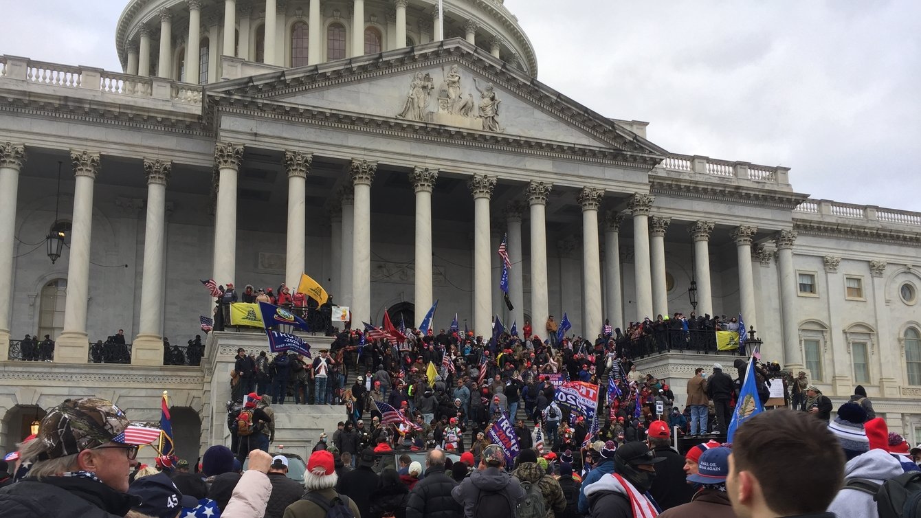 A group of right wing protesters outside the Capitol building in Washington DC. They are climbing the Stairs of the building.