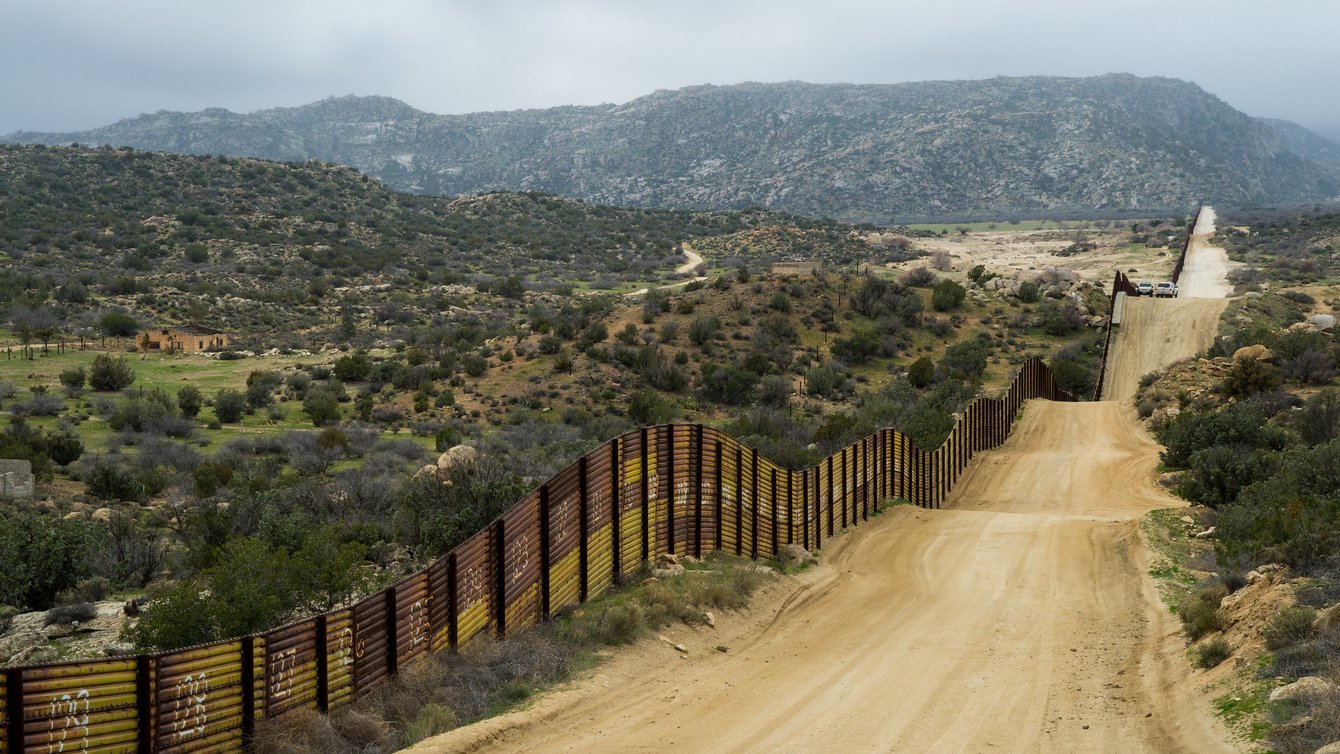 Long dirt road along border wall