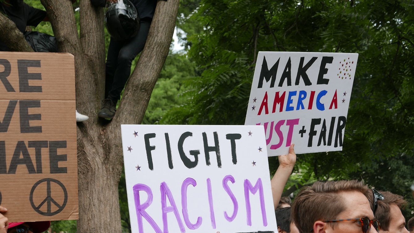 A person holding a sign saying "Fight Racism"