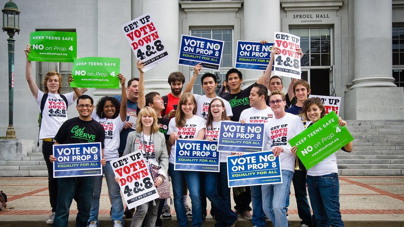 A group of people holding signs that read "Vote No on Prop 8"
