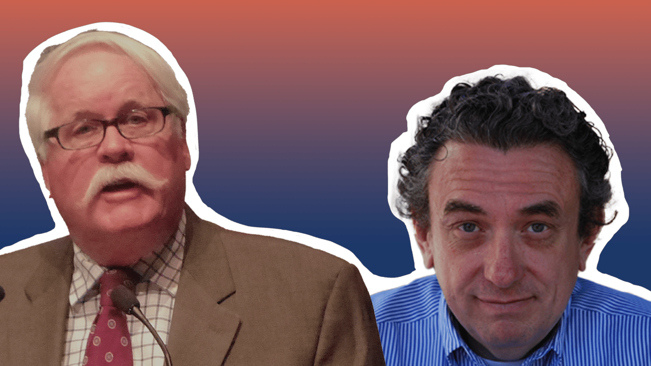 A White man with white hair in a grey suit and a man in a blue shirt.