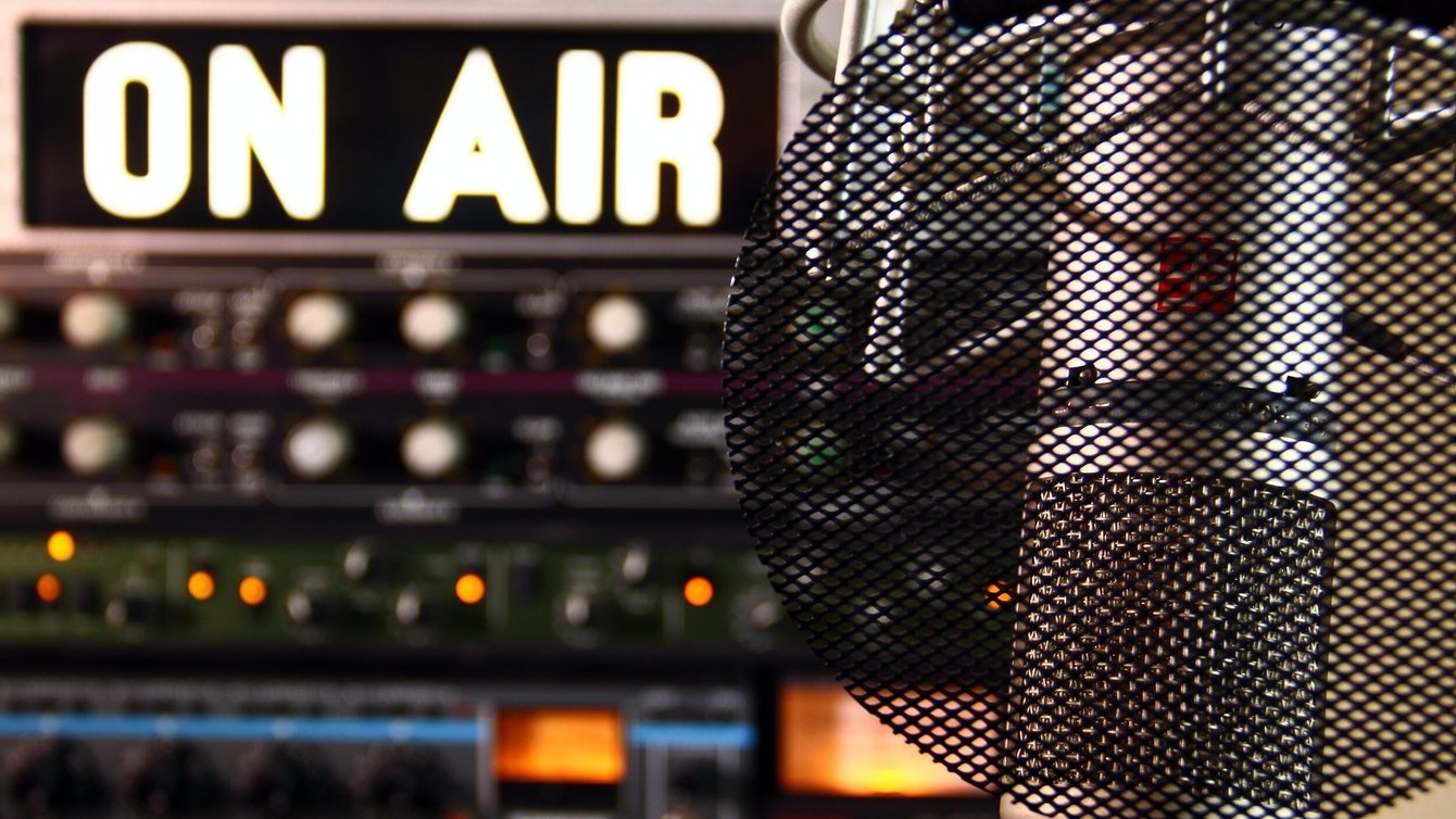 An illuminated "on air" sign and a microphone