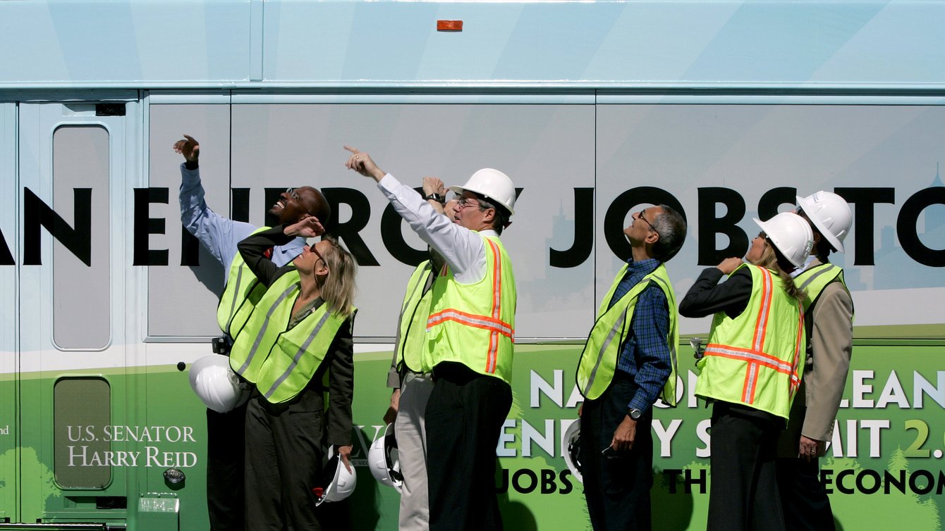 People in hi visibility jackets pointing upwards.