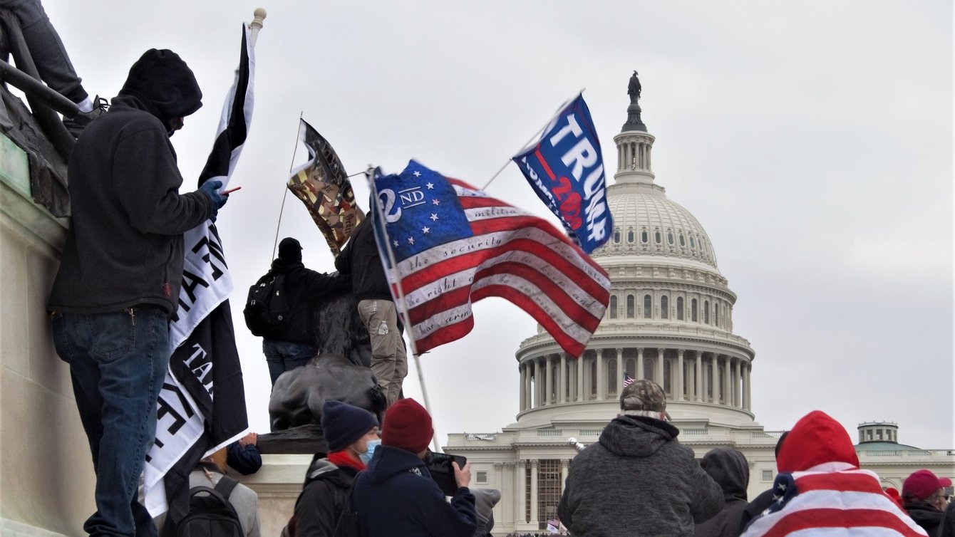 People holding flags of various groups like 2 percenters and Trump flags.