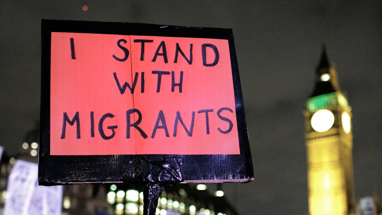 Protestor holds a sign that says "I stand with immigrants"
