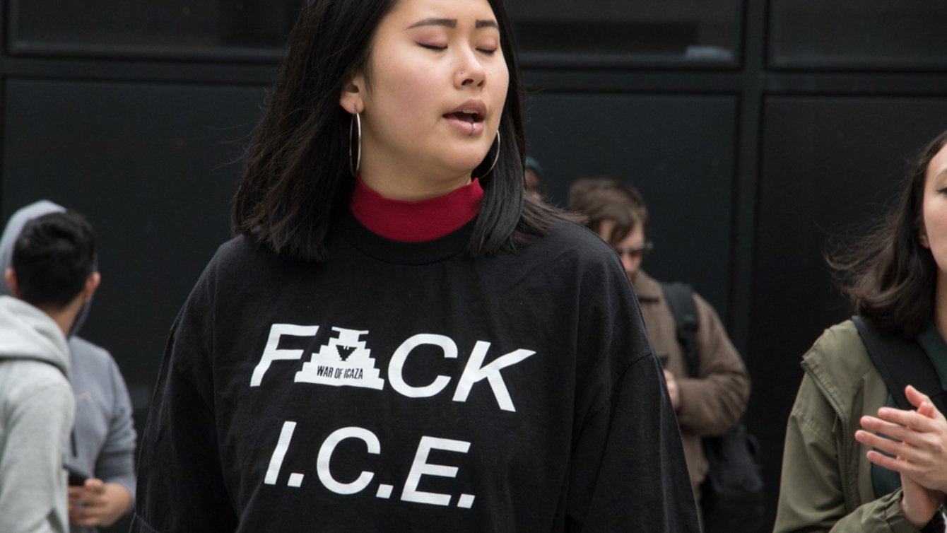 A woman with her eyes closed wearing a black shirt that says "F ck ICE"