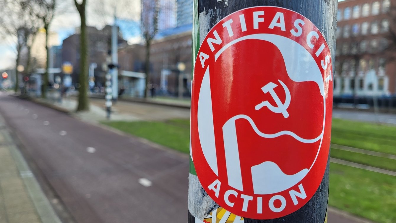 a red sticker on a black pole reads "antifascist action"