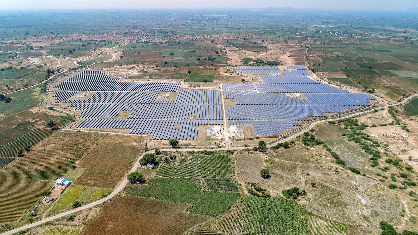 An aerial view of a solar panel field surrounded by bare fields