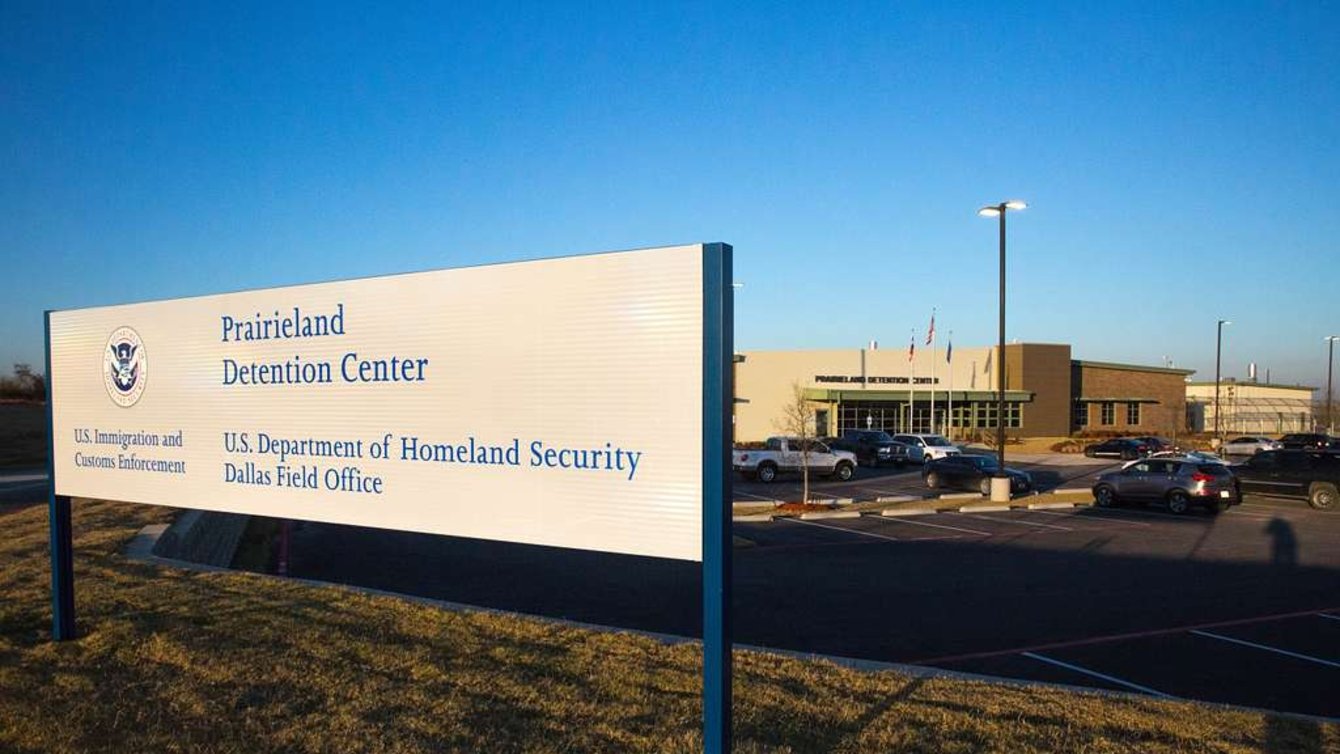 a white sign reads "prairieland detention center" in front of a low brick building
