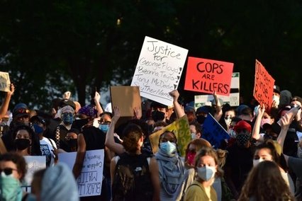 Protesters with fists in the air and holding boards of protest