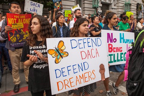 Protesters hold various signs and banners at a DACA rally in San Francisco.