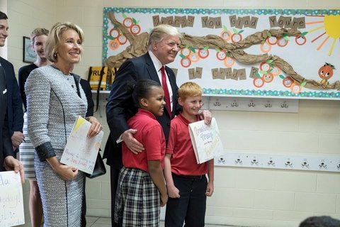 President Donald Trump and U.S. Secretary of Education Betsy DeVos poses for a photo with students of Saint Andrew Catholic School on March 3, 2017.