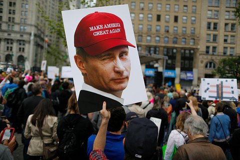 Protest sign of Putin wearing MAGA hat