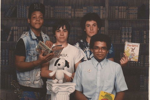Young Eric Ward posing with friends holding books