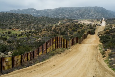 Long dirt road along border wall