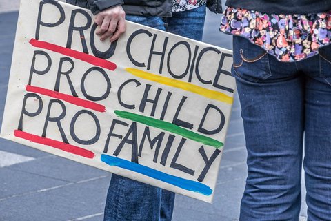 A banner at a protest that says "Pro Choice, Pro Child, Pro Family"