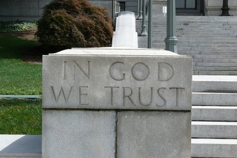  The word In God We Trust engraved in a stone staircase