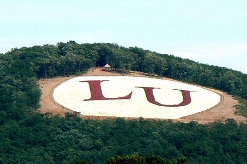 The letters LU in red on a green mountain