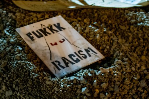 A sign that says Fukkk Racism