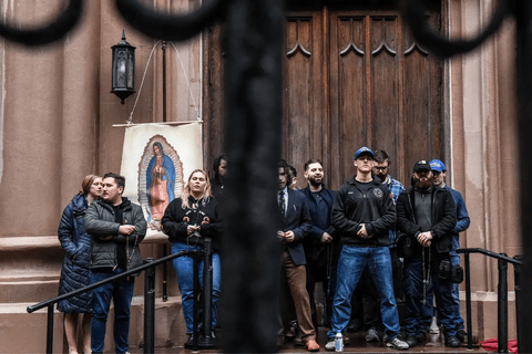 A group of people standing in front of a church.