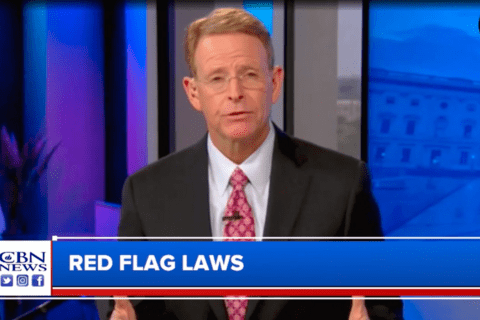 A white man in a suit with a news bar below him that says "Red Flag laws"