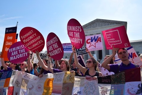 Women holding up signs that say "Feminist majority leadership alliances" in front of the Supreme Court