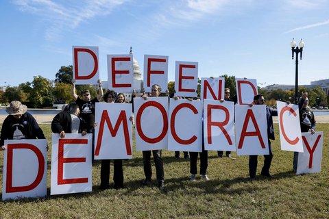 Protesters holding letters that spell out democracy
