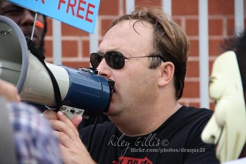 A white man speaking into a medaphone