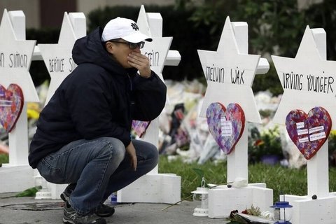 A man kneeling in front of a grave.