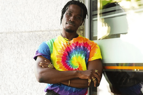 A black man in a rainbow tie-dye tshirt.