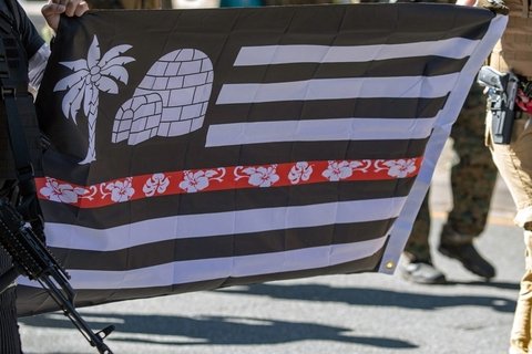 Two men carrying a Boogaloo Boys flag