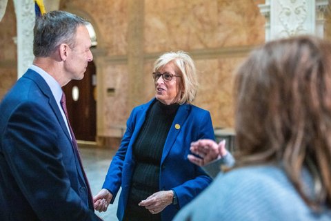 Two people in suits talking to each other.