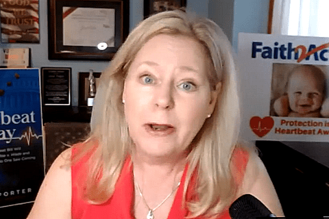 A woman with blond hair looking into the camera