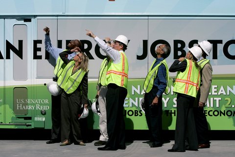 People in hi visibility jackets pointing upwards.