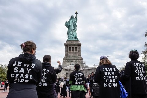 Statue of Liberty with people wearing hoodies saying "Jews Say Cease Fire"