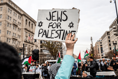 A protester holding up a sign that reads "Jews for Palestine"