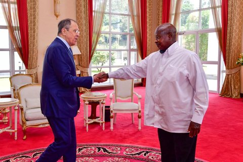 Two men shaking hands in a room with red carpet