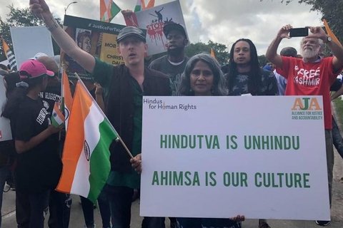 A group of people holding a sign that says "Hidutva is unhindu, Ahimsa is our culture."