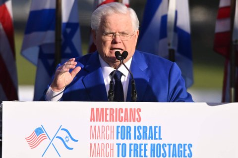 a man in a blue suit talking into a microphone