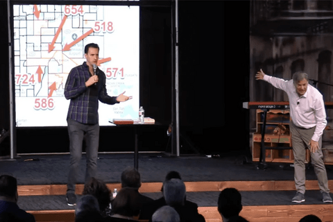 A man on a stage talking into a microphone