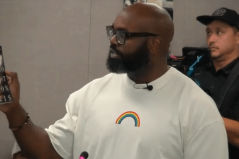 a black man in a white t shirt with a rainbow on it.