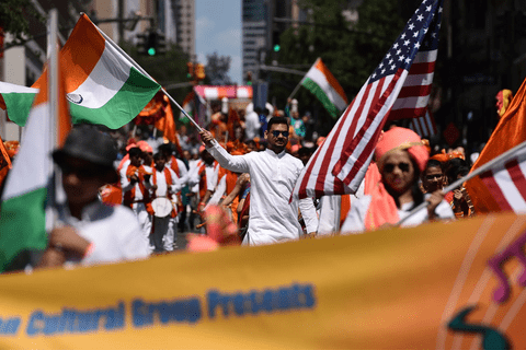 People waving indian and american flags in a parade