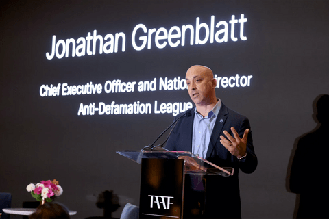 Jonathan Greenblatt standing in front of a projetion.